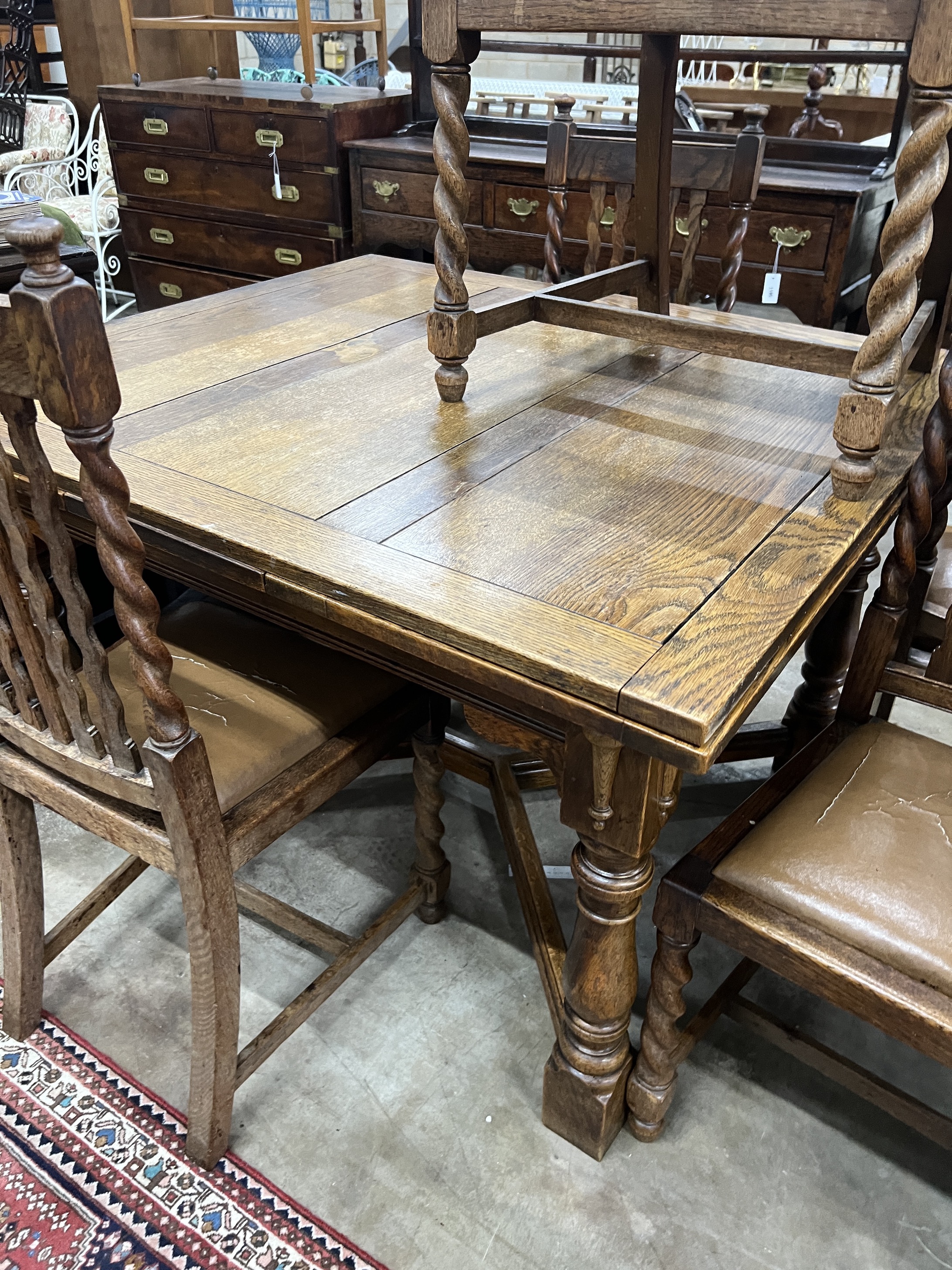 An early 20th century oak draw leaf dining table, width 120cm, depth 106cm, height 76cm together with five oak dining chairs, one with arms